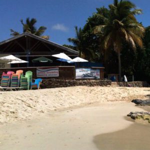 A beach with chairs and umbrellas on the sand.