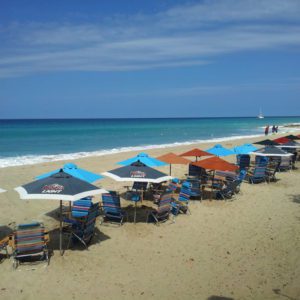 A beach with many chairs and umbrellas on it