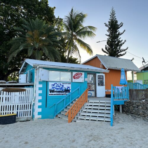 A beach house with stairs leading to the front of it.