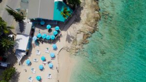 An aerial view of a beach with umbrellas and chairs.