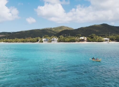 A person in a boat floating on top of the ocean.