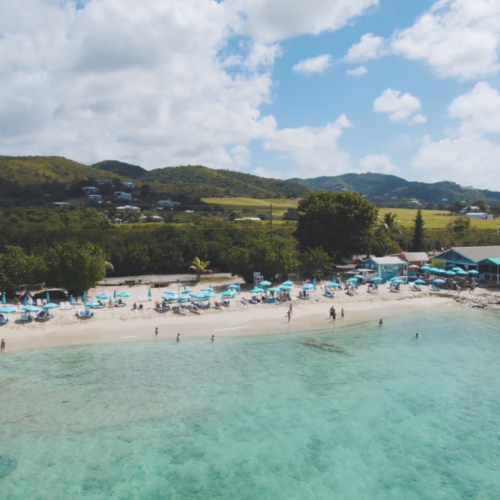 A beach with people swimming and lounging on it.